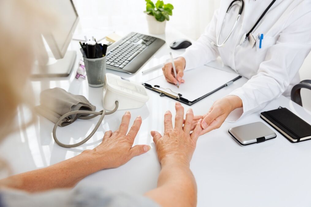 zdravnik pregleda roke z artrozo